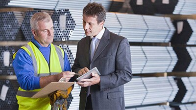 two men speaking in a factory