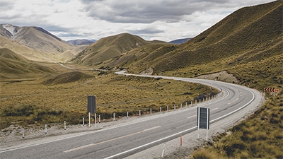  long road in green hills in New Zealand